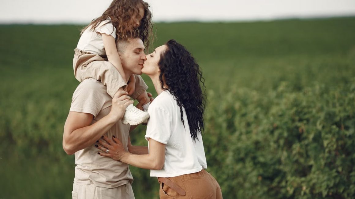 A heartwarming family moment captured in a field, highlighting love and togetherness.